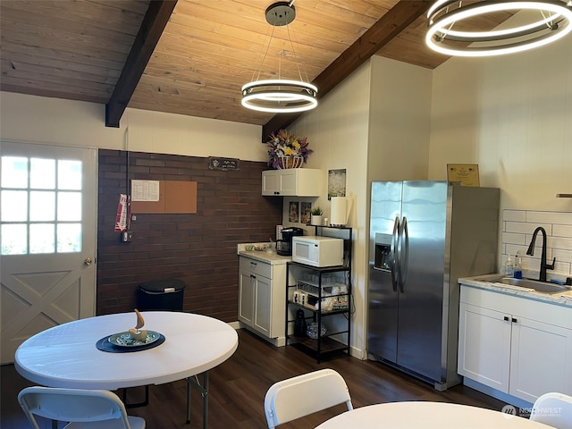 dining space with brick wall, wooden ceiling, beam ceiling, dark hardwood / wood-style floors, and sink