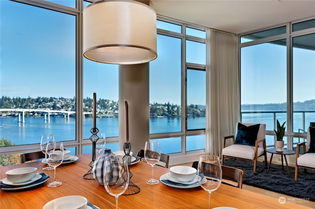 dining space featuring floor to ceiling windows and a water view