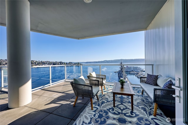 balcony featuring an outdoor living space and a water view