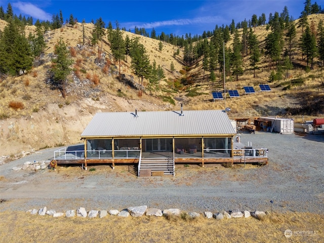 back of property featuring a sunroom and a mountain view