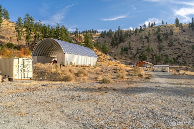 view of outdoor structure with a carport and a mountain view