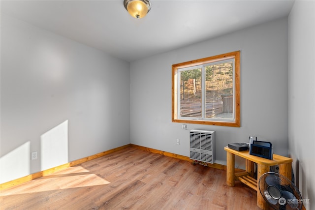 unfurnished room with light wood-type flooring and radiator