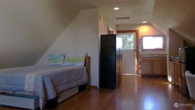 1555 Swartout Rd, Manson, WA 98831 - bedroom with a sink, vaulted ceiling, wood finished floors, freestanding refrigerator, and recessed lighting