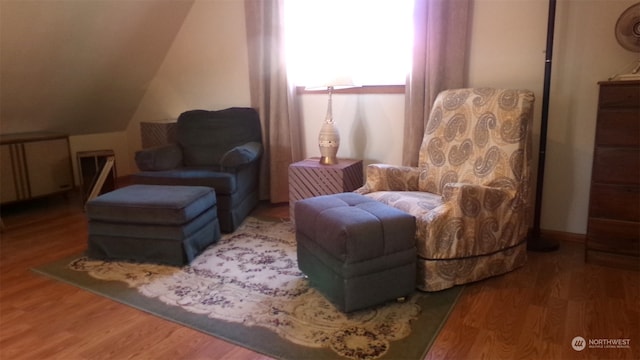 living area featuring hardwood / wood-style flooring, lofted ceiling, and radiator heating unit