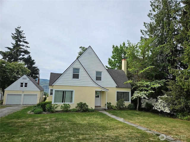 1555 Swartout Rd, Manson, WA 98831 - view of front of property with an outbuilding, a chimney, stucco siding, a front lawn, and a detached garage