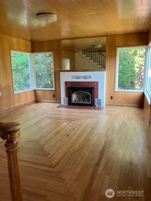 1555 Swartout Rd, Manson, WA 98831 - unfurnished living room featuring wooden walls, a fireplace, and wood finished floors