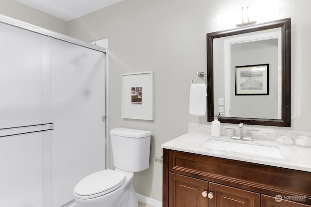 bathroom with vanity, toilet, and a shower with shower door