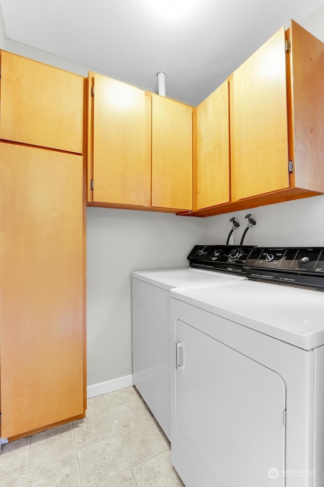 clothes washing area featuring cabinets and washing machine and dryer