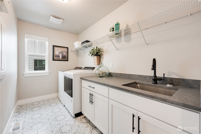 clothes washing area with cabinets, light tile patterned flooring, washer and dryer, and sink