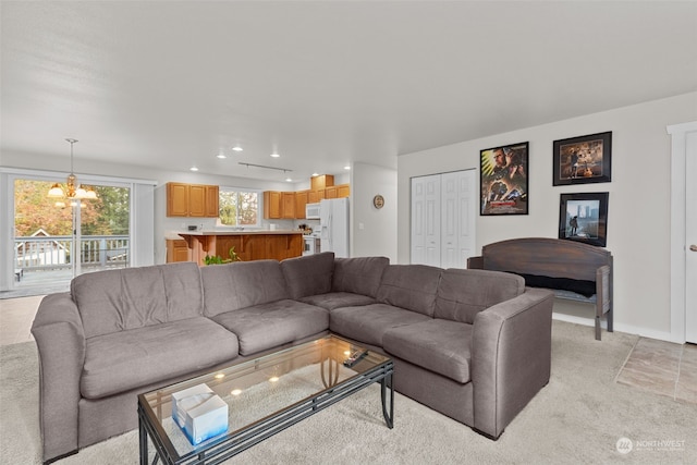 living room with light carpet and a notable chandelier