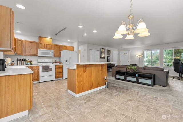 kitchen with sink, pendant lighting, a notable chandelier, a center island, and white appliances