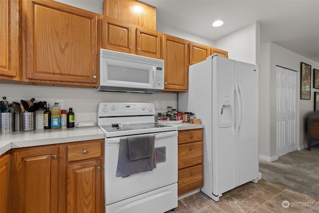 kitchen featuring carpet flooring and white appliances