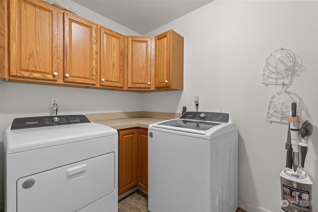 washroom with cabinets and washer and clothes dryer