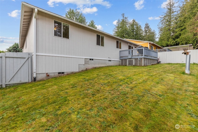 rear view of house with a yard and a deck