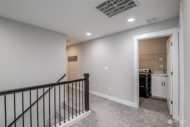 hall featuring sink, washer / clothes dryer, and light colored carpet