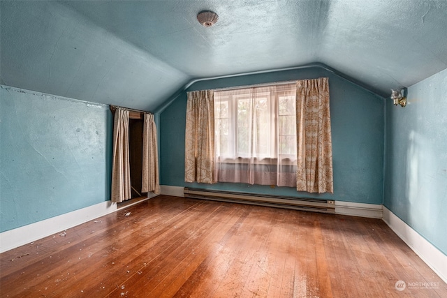 bonus room with a textured ceiling, lofted ceiling, hardwood / wood-style floors, and baseboard heating