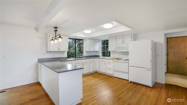 kitchen with light hardwood / wood-style floors, white appliances, kitchen peninsula, hanging light fixtures, and white cabinetry