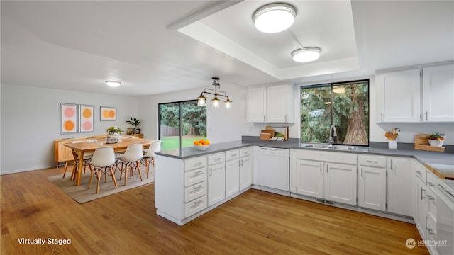 kitchen with kitchen peninsula, white cabinets, light hardwood / wood-style flooring, and white dishwasher