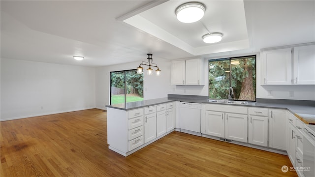 kitchen with dishwasher, kitchen peninsula, and white cabinetry