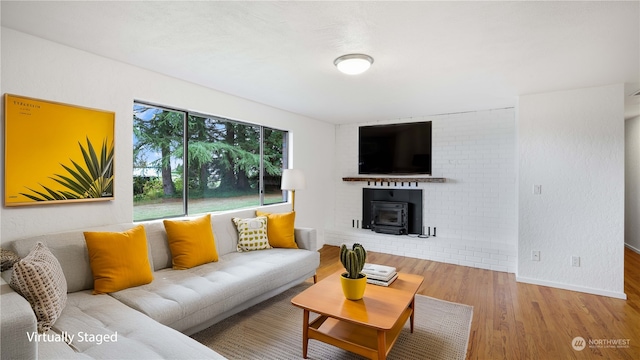 living room featuring a wood stove and wood-type flooring