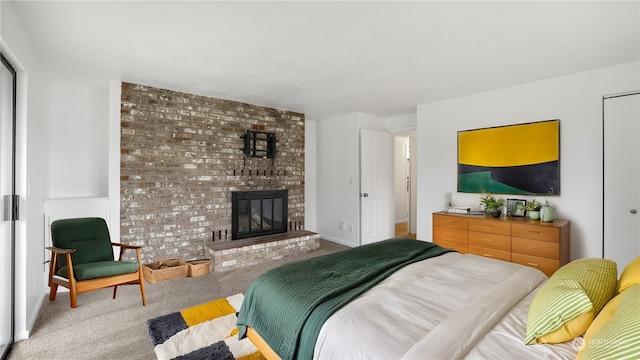 carpeted bedroom with a brick fireplace and a closet