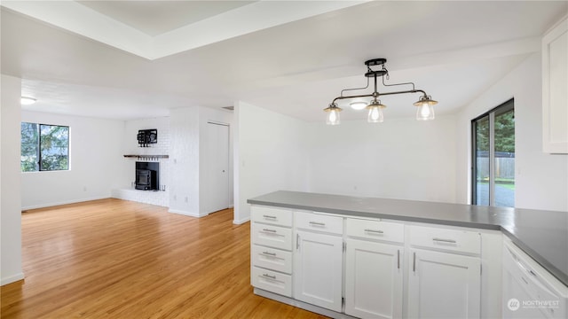 kitchen featuring a healthy amount of sunlight, light hardwood / wood-style floors, white dishwasher, and white cabinetry