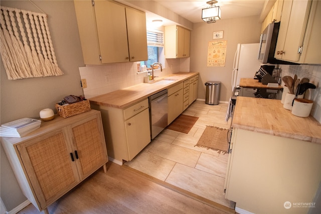 kitchen featuring stainless steel appliances, light wood-type flooring, sink, and tasteful backsplash