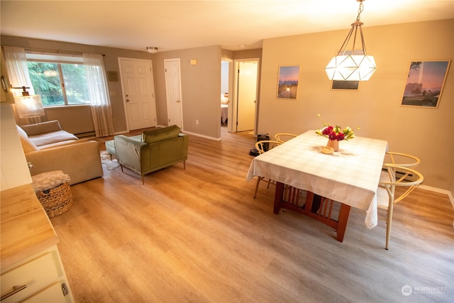 dining area with baseboard heating and light hardwood / wood-style flooring