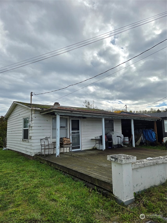 rear view of house with a deck and a yard