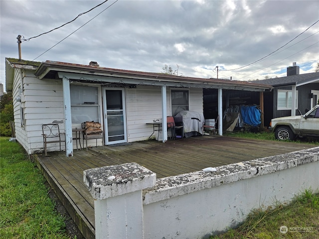 rear view of house featuring a wooden deck