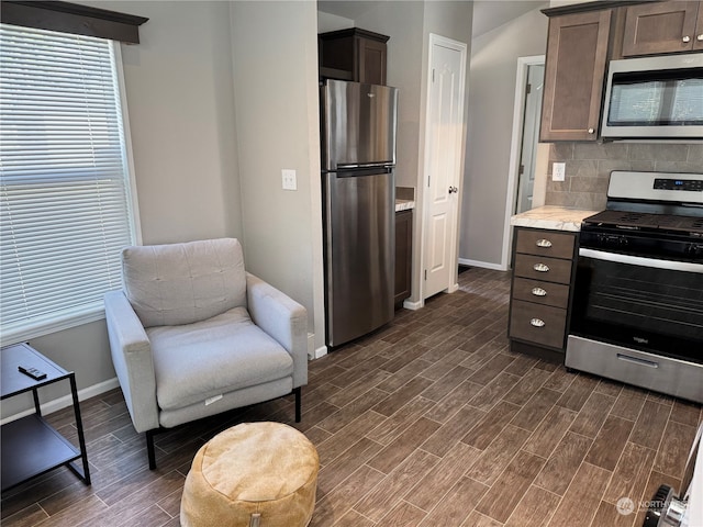 kitchen with stainless steel appliances, dark hardwood / wood-style floors, decorative backsplash, and dark brown cabinetry