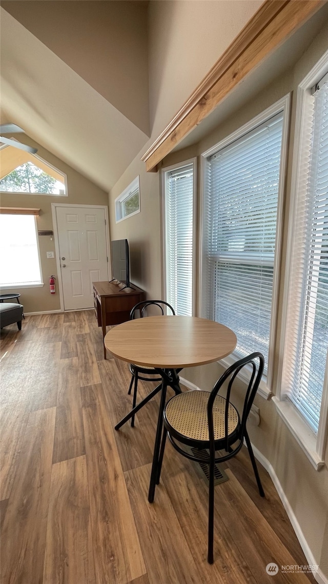 dining space featuring lofted ceiling and wood-type flooring