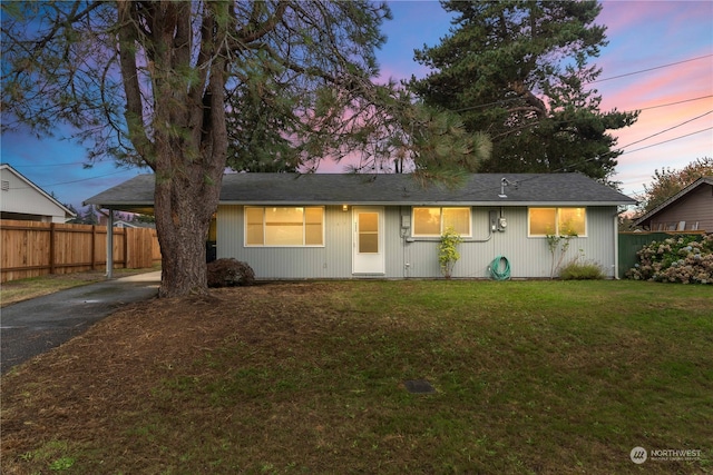 single story home featuring a carport and a lawn