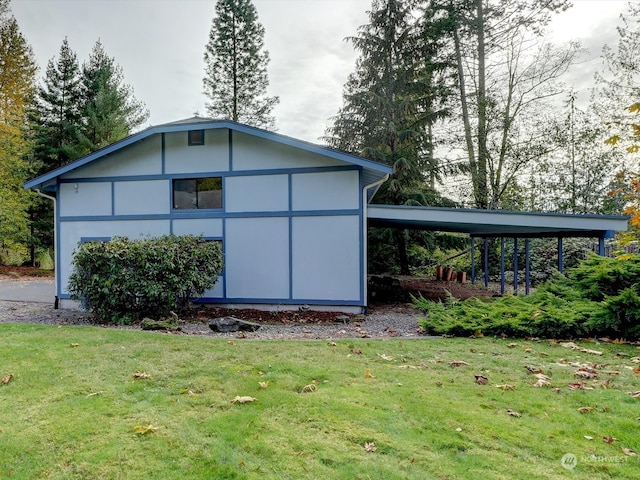 view of outdoor structure featuring a lawn and a carport