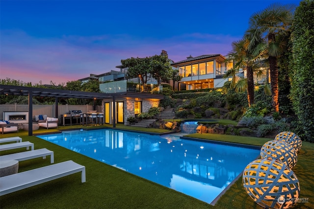 pool at dusk with an outdoor living space, a pergola, a lawn, and a patio area