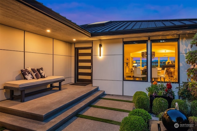 exterior entry at dusk featuring a patio