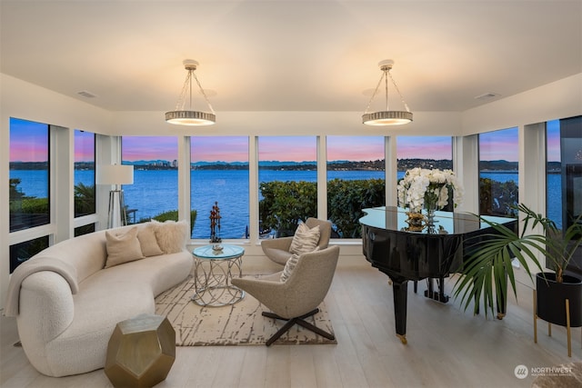 living room with a water view and light hardwood / wood-style flooring