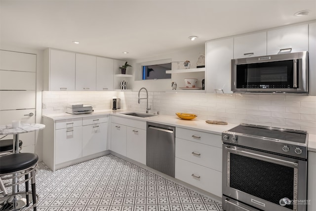 kitchen with appliances with stainless steel finishes, white cabinetry, and sink