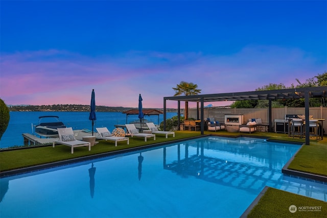 pool at dusk with an outdoor living space, a pergola, a water view, and a lawn