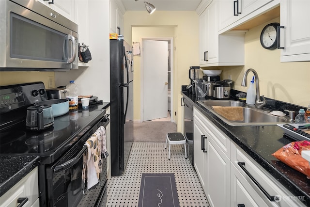 kitchen featuring sink, white cabinetry, and black appliances