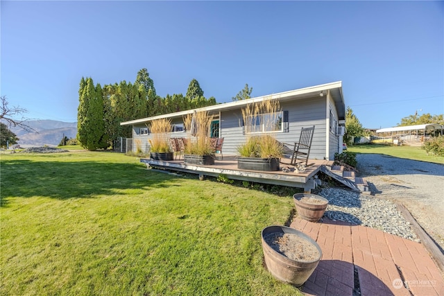 view of front facade featuring a deck with mountain view and a front lawn