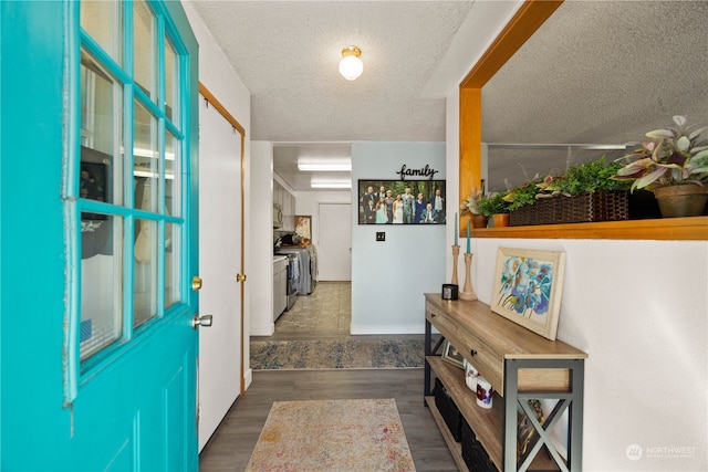 foyer entrance with dark hardwood / wood-style floors and a textured ceiling