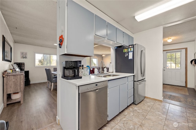 kitchen featuring a textured ceiling, stainless steel appliances, plenty of natural light, and sink