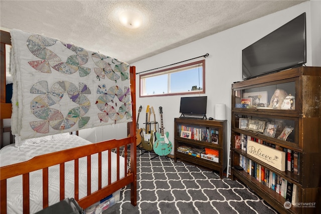 bedroom with dark carpet and a textured ceiling