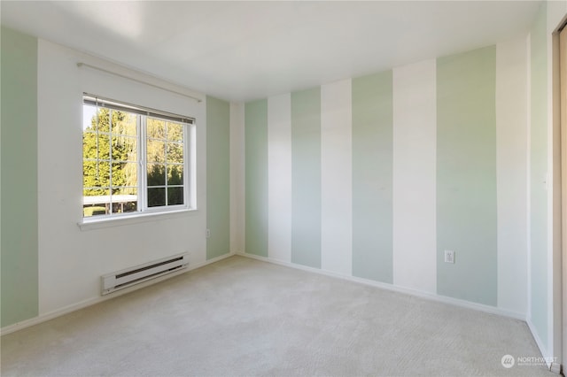 carpeted spare room featuring a baseboard radiator