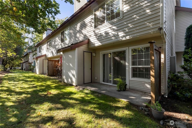 back of house with a yard and a patio