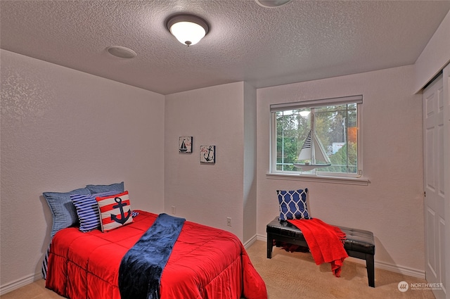 bedroom with a closet, a textured ceiling, and carpet