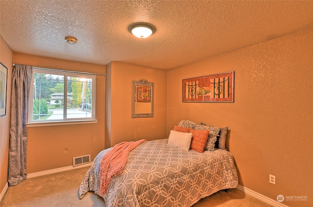 bedroom with a textured ceiling and carpet