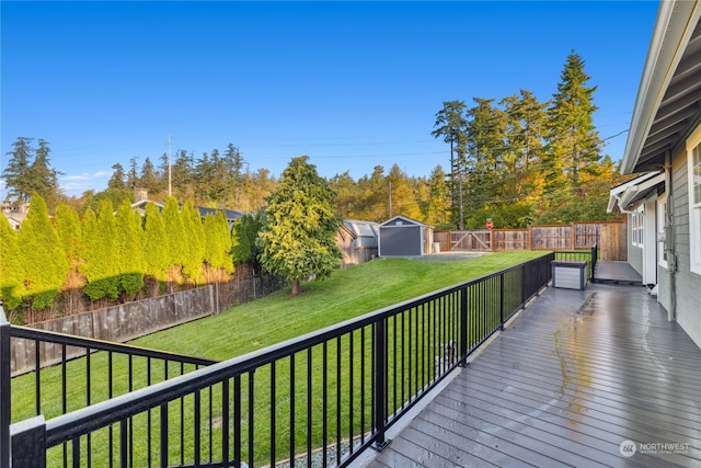 wooden deck with a storage unit and a lawn