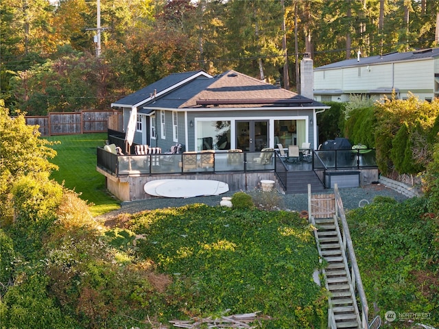 rear view of house with a lawn and a wooden deck